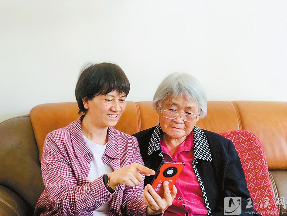 丁樹芬正在給90歲的老同志聶淑芬演示如何使用“學(xué)習(xí)強(qiáng)國(guó)”App。 （圖片由丁樹芬提供）