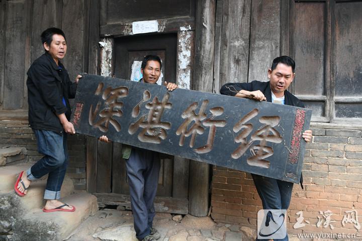 張耀文向游客展示自家珍藏的匾額。