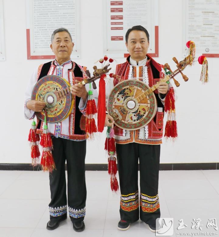 彝家男子身穿民族服飾彈四弦。