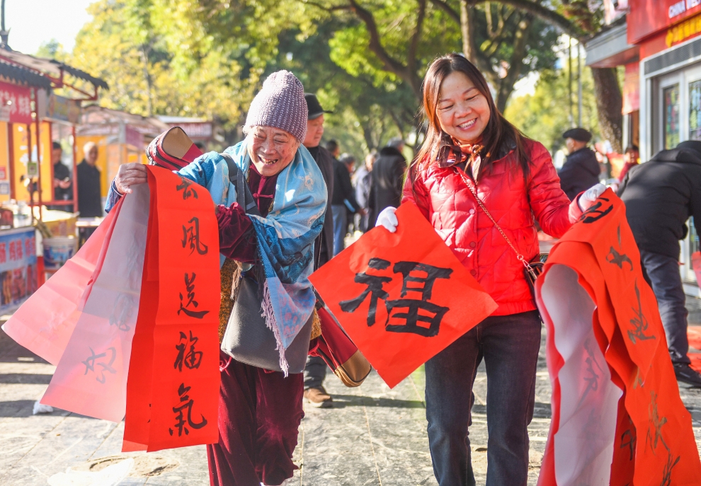 2025年1月13日，在湖南省永州市道縣西洲公園義工崗?fù)?，市民們領(lǐng)到了書法志愿者為大家書寫的春聯(lián)。